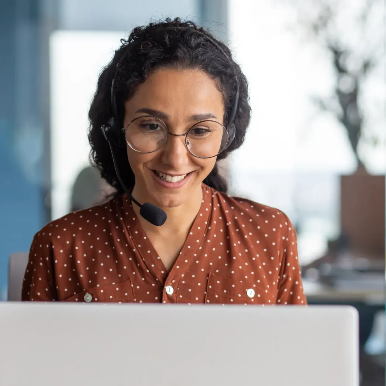 Help desk technician working at a computer and wearing a headset.